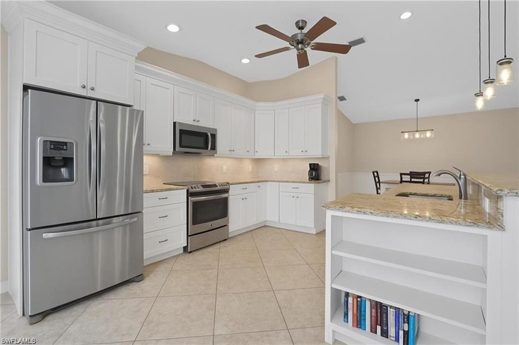 6060 Painted Leaf Lane Naples, FL 34116 - Photo 11 of 49 a kitchen with granite countertop a refrigerator a sink and dishwasher