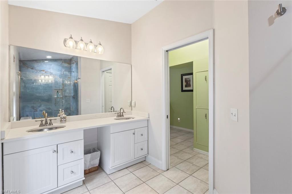 6060 Painted Leaf Lane Naples, FL 34116 - Photo 19 of 49 a bathroom with a sink vanity and mirror