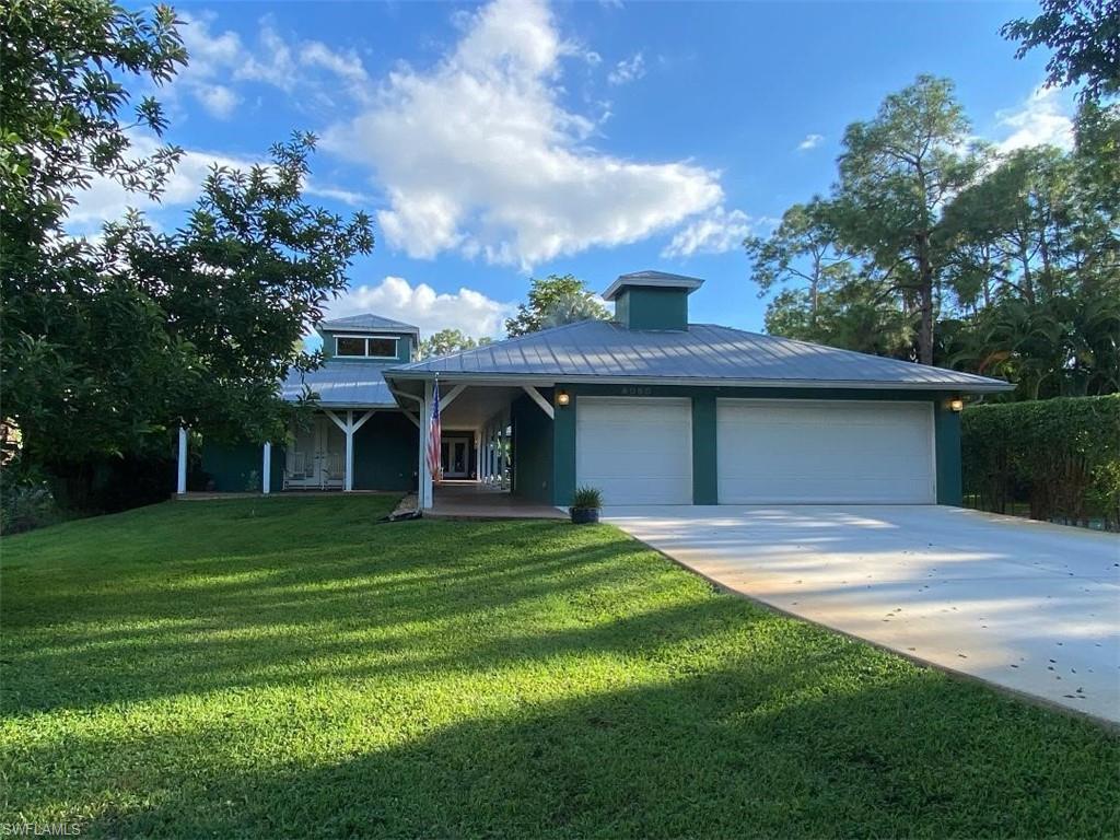 6060 Painted Leaf Lane Naples, FL 34116 - Photo 2 of 49 a front view of a house with a yard and trees