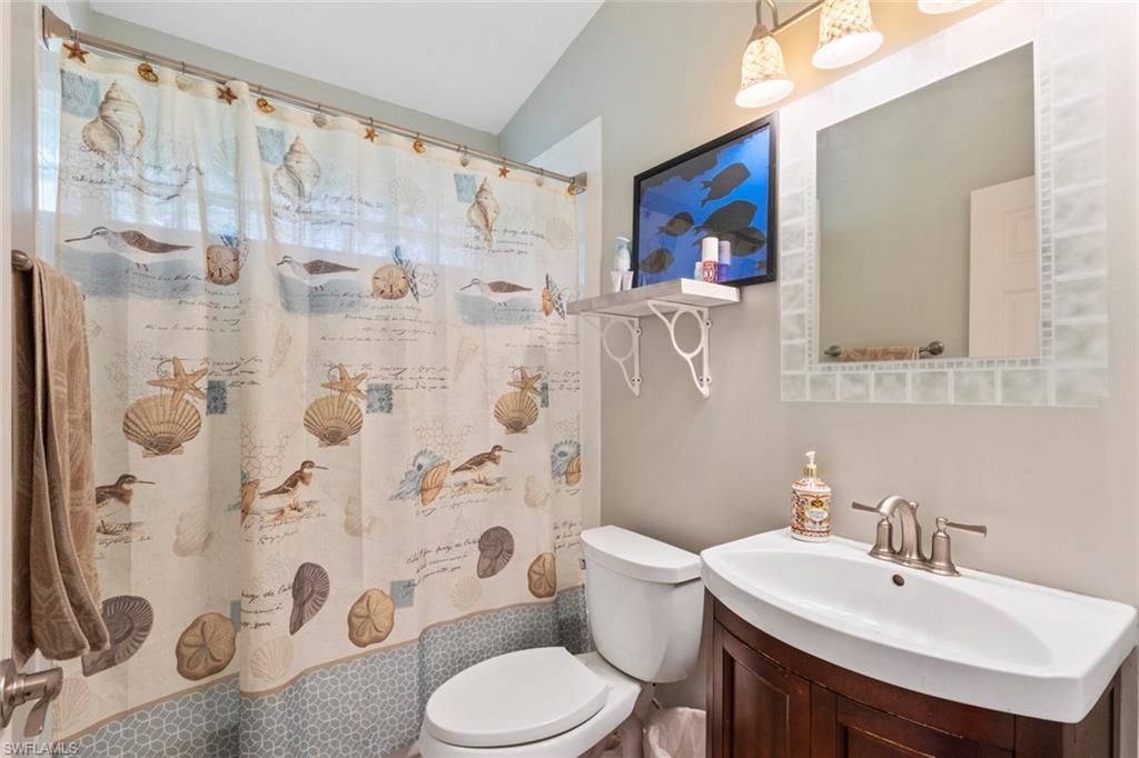 6060 Painted Leaf Lane Naples, FL 34116 - Photo 22 of 49 a bathroom with a sink a toilet and shower curtain