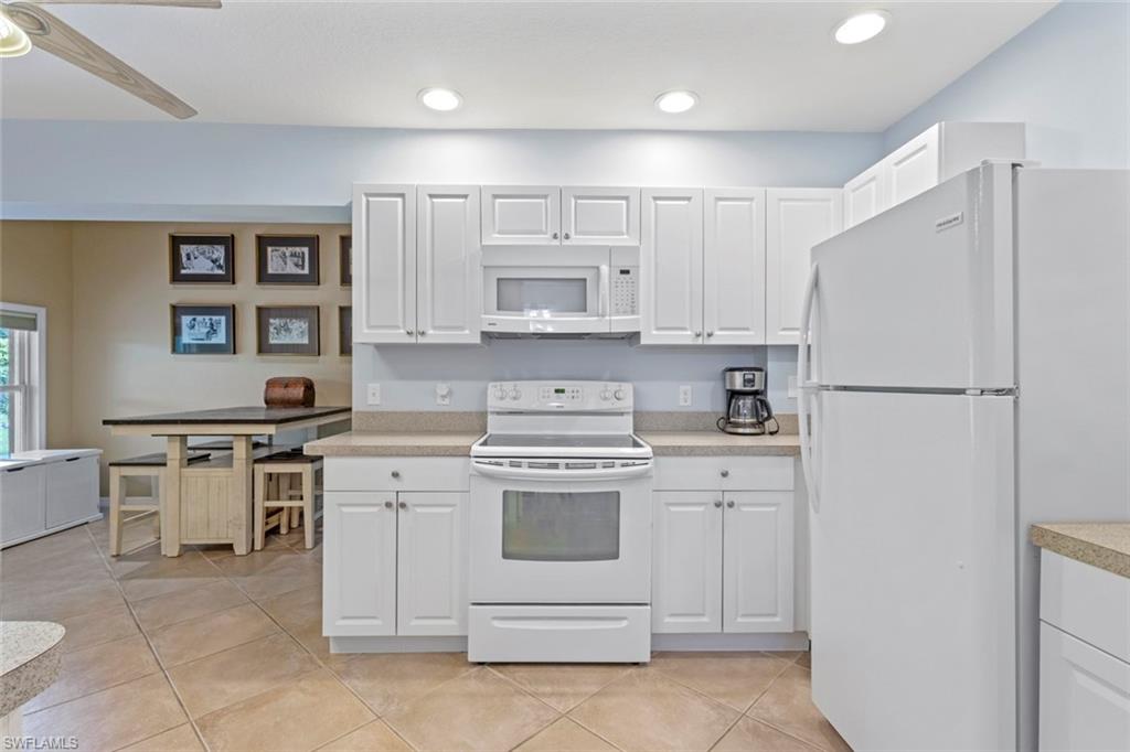 6060 Painted Leaf Lane Naples, FL 34116 - Photo 32 of 49 a kitchen with a stove oven and white cabinets
