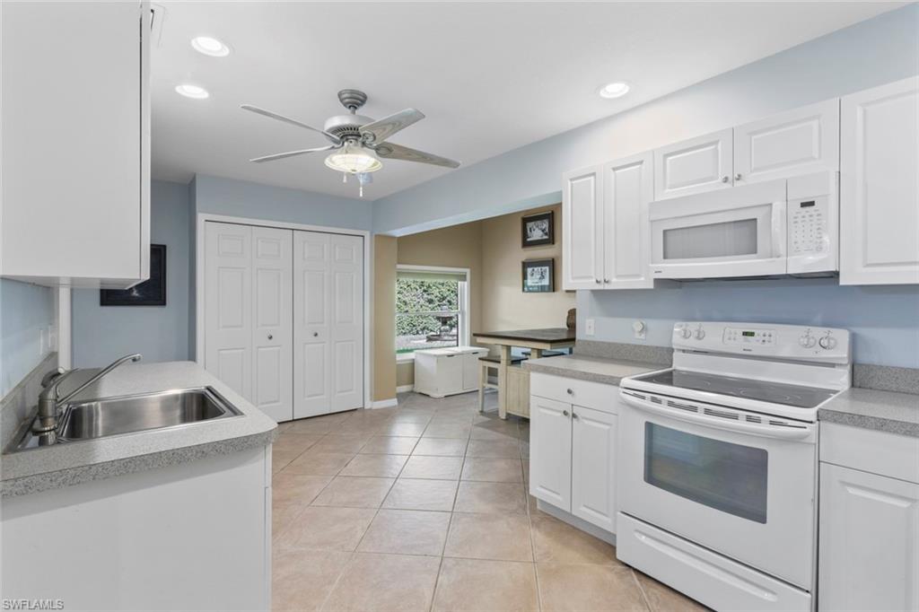 6060 Painted Leaf Lane Naples, FL 34116 - Photo 33 of 49 a kitchen with cabinets stainless steel appliances and a sink