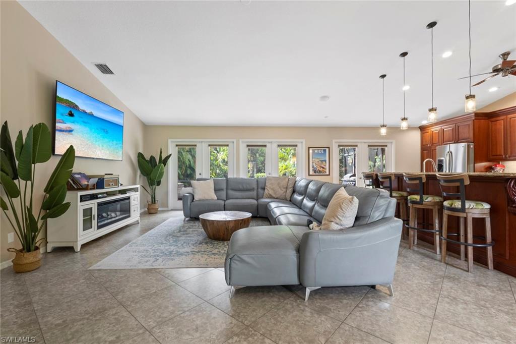 6060 Painted Leaf Lane Naples, FL 34116 - Photo 6 of 49 a living room with fireplace furniture and a flat screen tv