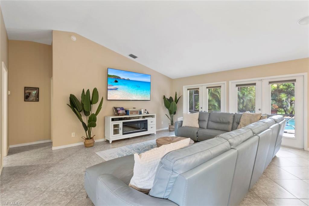 6060 Painted Leaf Lane Naples, FL 34116 - Photo 7 of 49 a living room with furniture a fireplace and a flat screen tv
