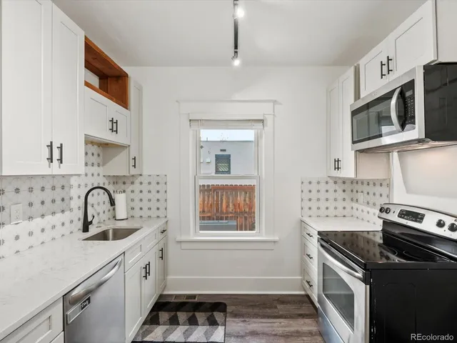 a kitchen with stainless steel appliances a refrigerator stove and sink