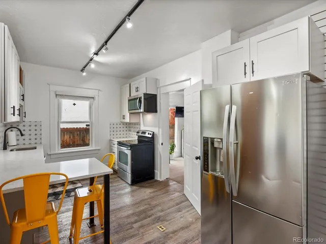 a view of a kitchen with sink and dishwasher with wooden floor