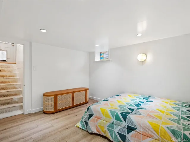 a bedroom with bed and wooden floor