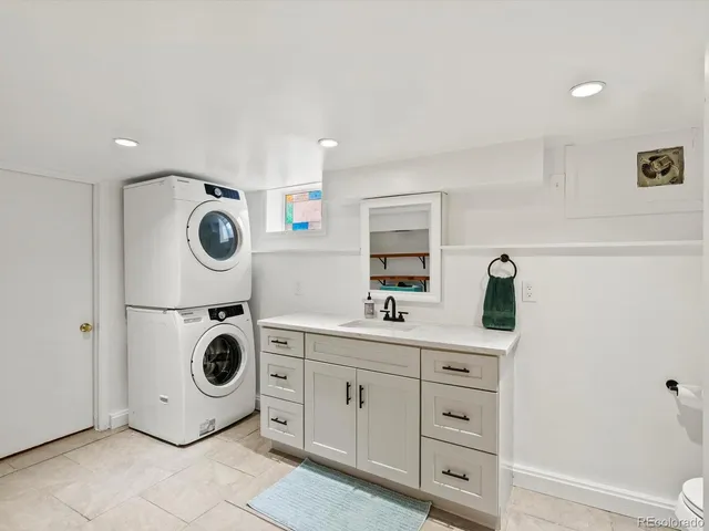 a bathroom with a double vanity sink a toilet and shower