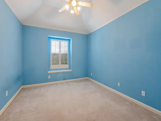 an empty room with chandelier fan and closet area