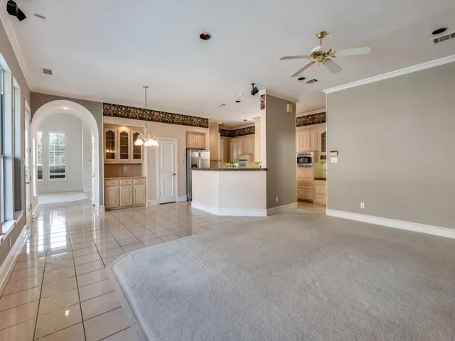 a view of a hallway with wooden floor and a kitchen