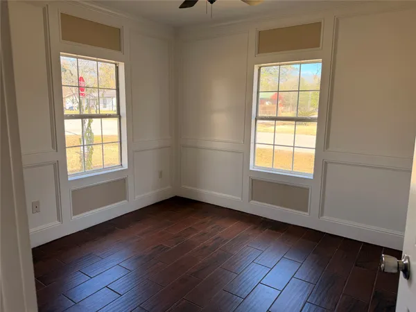 an empty room with wooden floor and windows