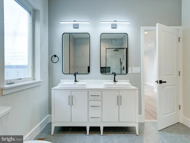 a bathroom with double vanity sinks and a mirror