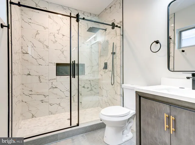 a bathroom with a shower a toilet and a sink