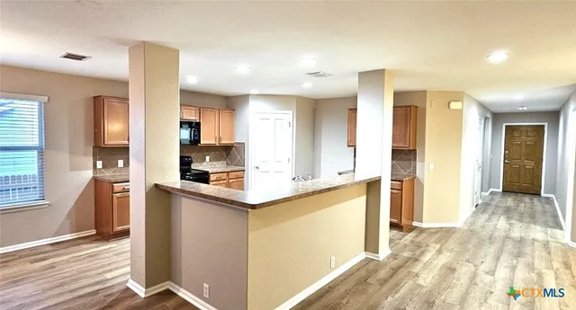 a kitchen with stainless steel appliances granite countertop a refrigerator and a sink
