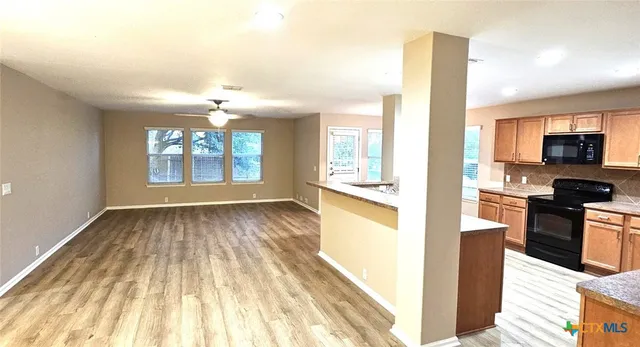 a view of a kitchen with wooden floor and electronic appliances