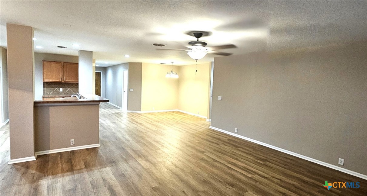 6046 Mule Deer Schertz, TX 78108 - Photo 9 of 19 a view of a kitchen with wooden floor and cabinets