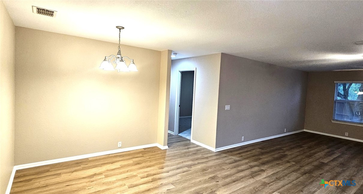 6046 Mule Deer Schertz, TX 78108 - Photo 10 of 19 a view of an empty room with wooden floor and a window