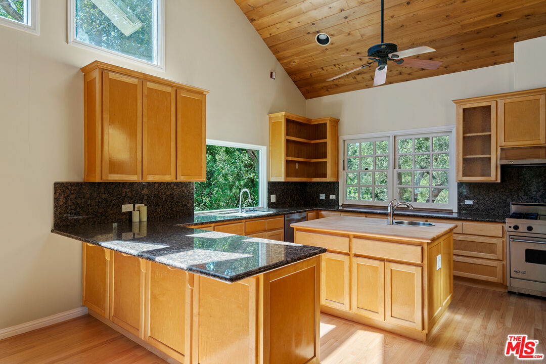 20912 Fontaine Road Topanga, CA 90290 - Photo 10 of 52 a kitchen with stainless steel appliances granite countertop a sink stove and refrigerator