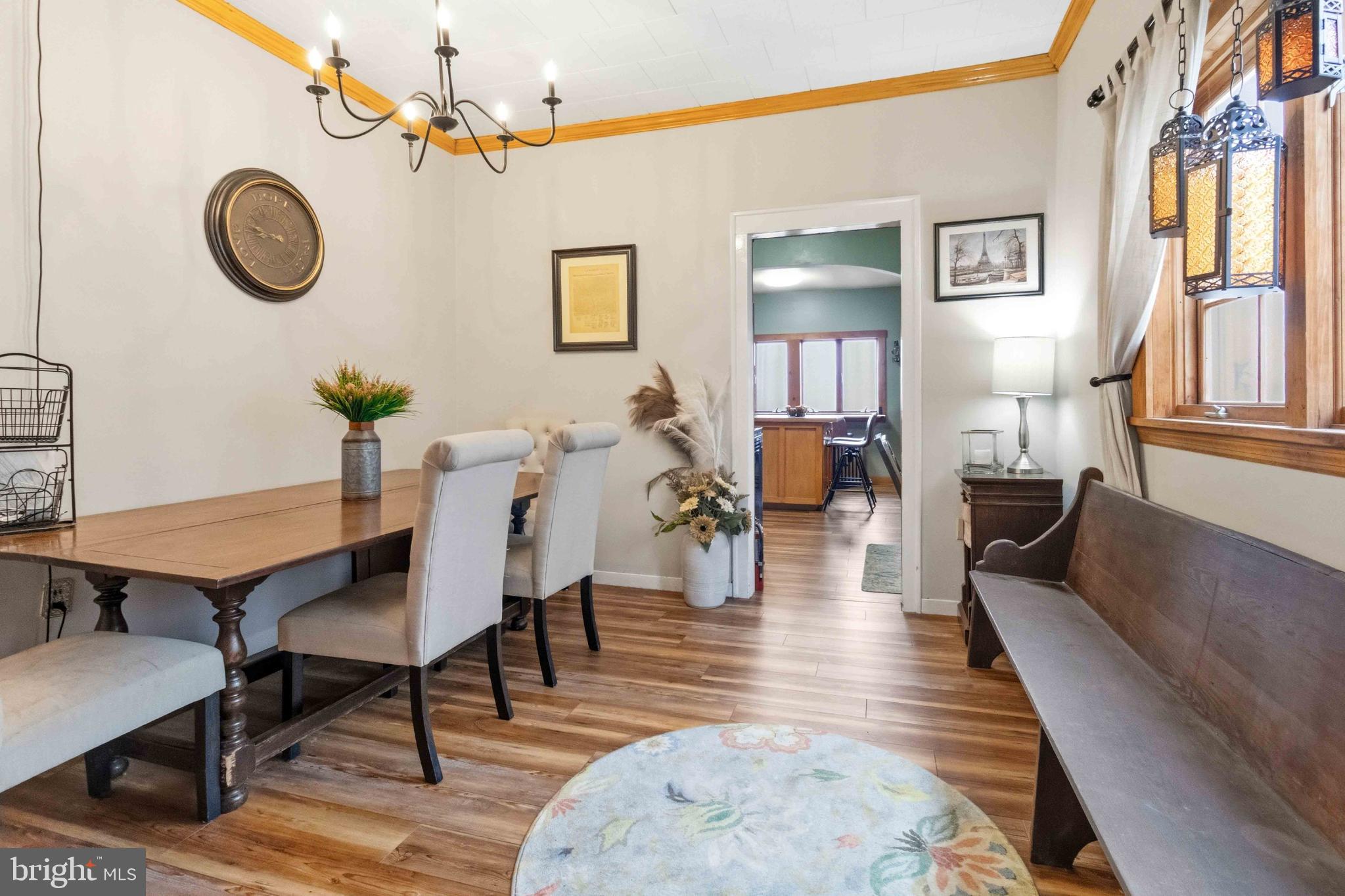 38 State Road Barnesville, PA 18214 - Photo 11 of 46 a living room with couches a dining table and paintings on the wall with wooden floor