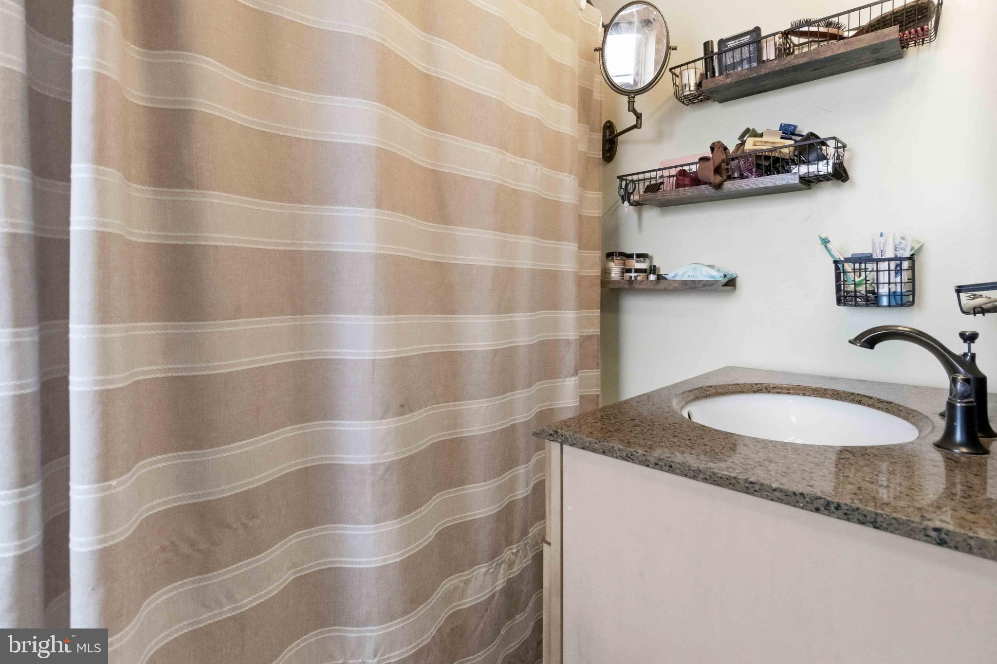 38 State Road Barnesville, PA 18214 - Photo 22 of 46 a bathroom with a granite countertop sink a mirror and shower