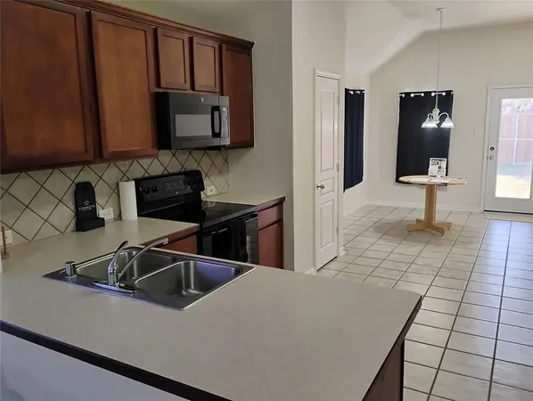 a kitchen with granite countertop a sink and a stove top oven