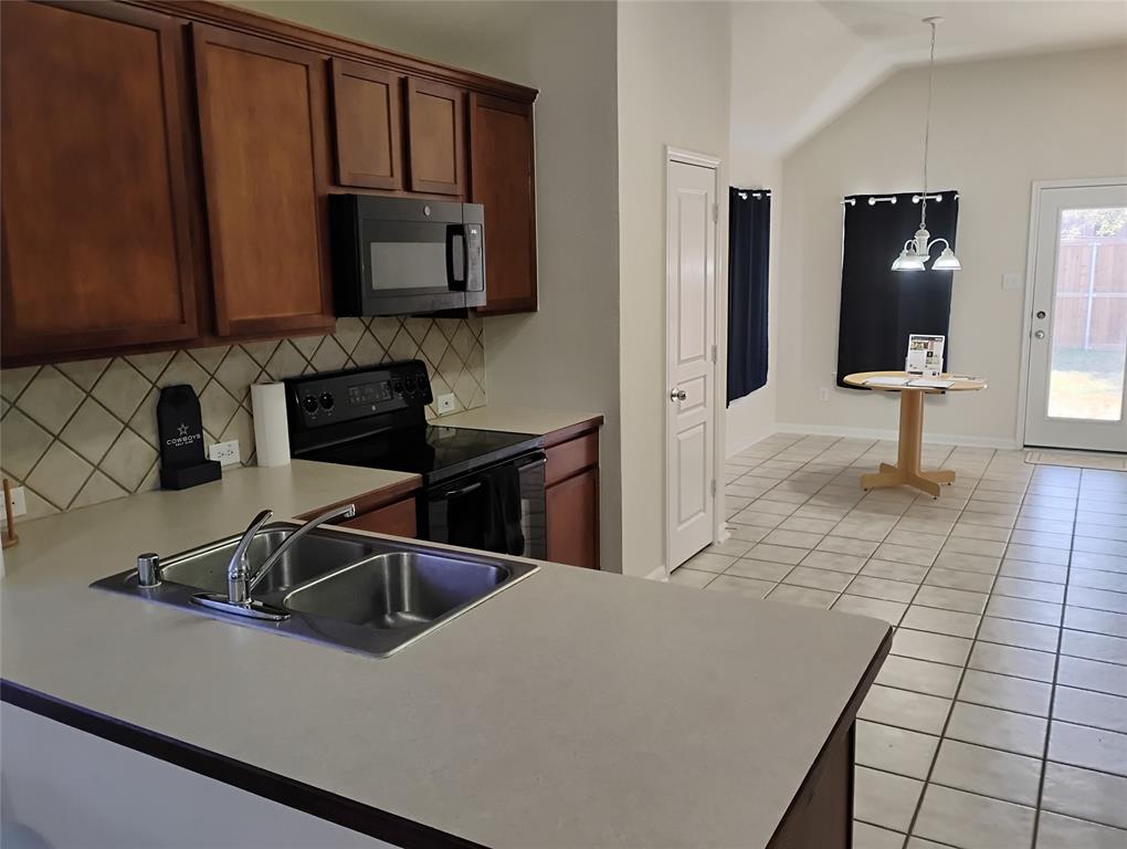 11705 Netleaf Lane Fort Worth, TX 76244 - Photo 8 of 20 a kitchen with granite countertop a sink and a stove top oven