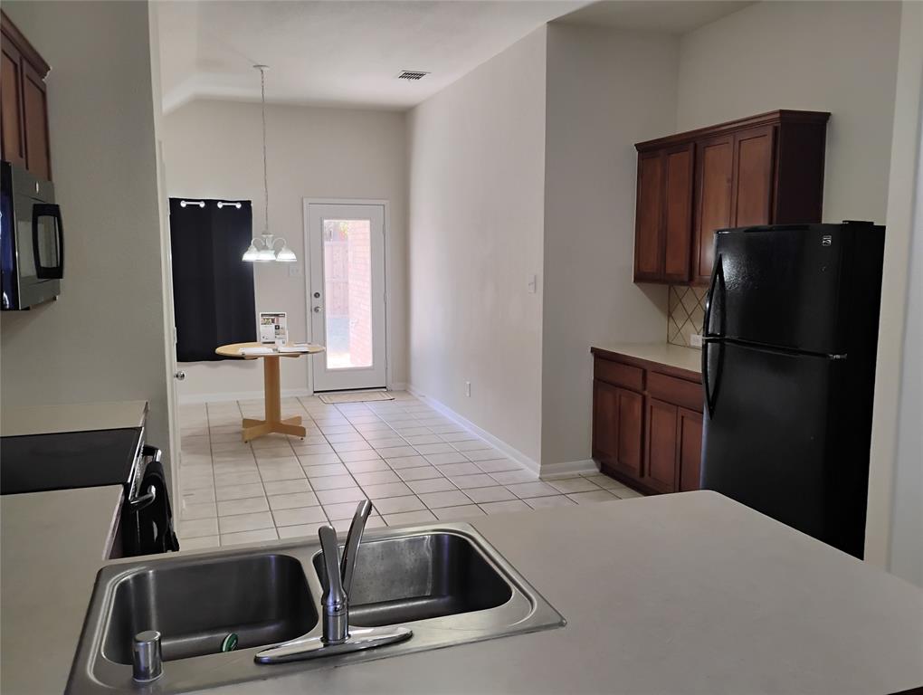 11705 Netleaf Lane Fort Worth, TX 76244 - Photo 9 of 20 a kitchen with a sink and refrigerator