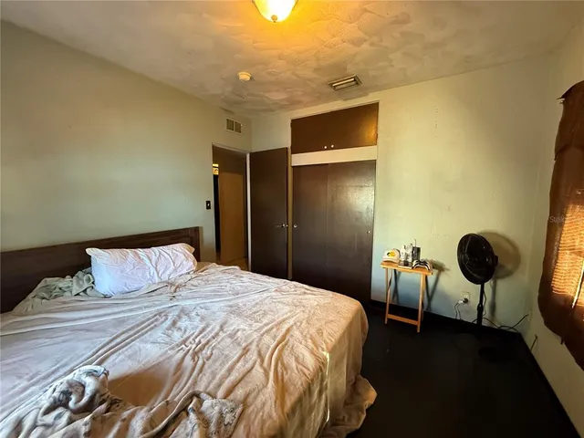 a view of a wooden house with a small yard and wooden fence