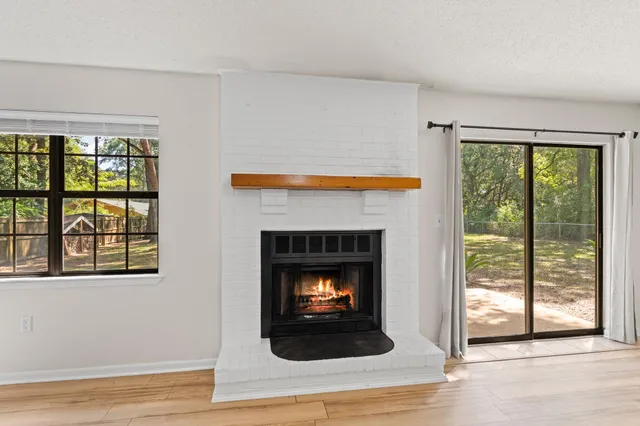 a living room with a fireplace and a floor to ceiling window