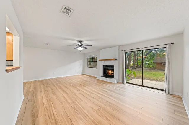 a view of an empty room with a fireplace and a floor to ceiling window