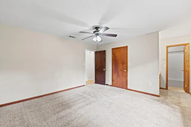 a view of a room with a ceiling fan and a window