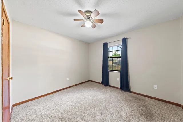 an empty room with closet and fan
