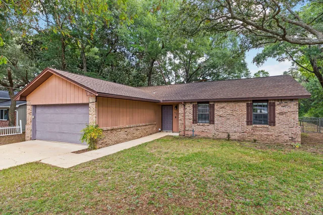 an empty room with wooden floor cabinet and windows