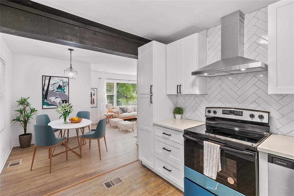 3406 Jackson Drive Decatur, GA 30032 - Photo 9 of 28 a kitchen with stainless steel appliances a stove a table and chairs in it
