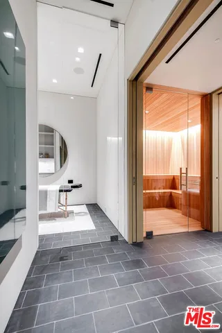 a bathroom with a glass door shower and a sink