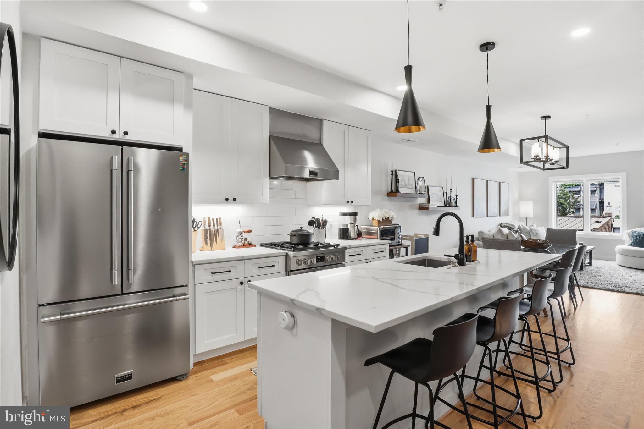 1222 Neal Street Northeast, Unit 3 Washington, DC 20002 - Photo 11 of 38 a kitchen with stainless steel appliances a stove a sink a refrigerator and chairs