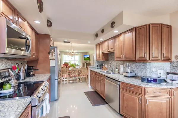 a kitchen with stainless steel appliances granite countertop a sink stove and cabinets