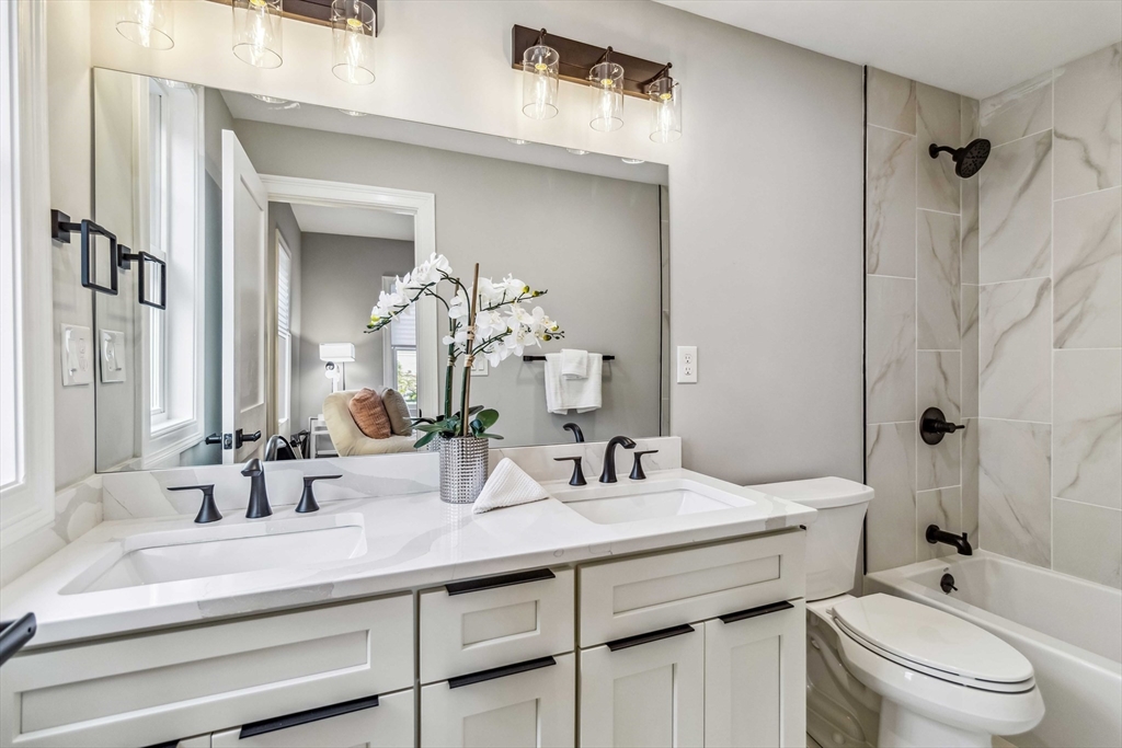 16 Alston Street, Unit 16 Somerville, MA 02143 - Photo 17 of 39 a bathroom with a double vanity sink toilet and shower