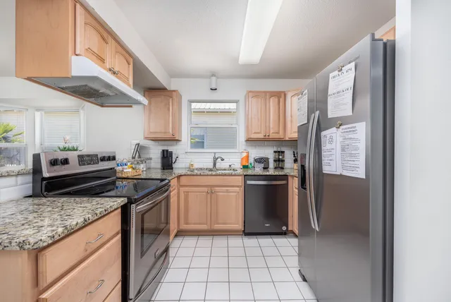 a kitchen with stainless steel appliances granite countertop a stove a sink and a refrigerator