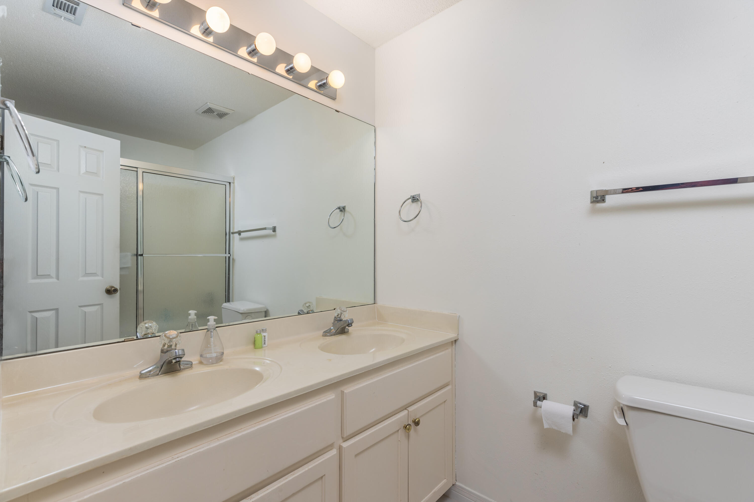 4450 Ocean View Drive Destin, FL 32541 - Photo 29 of 34 a bathroom with a sink a toilet and a large mirror