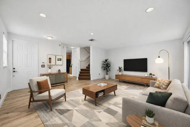 a living room with furniture and a wooden floor