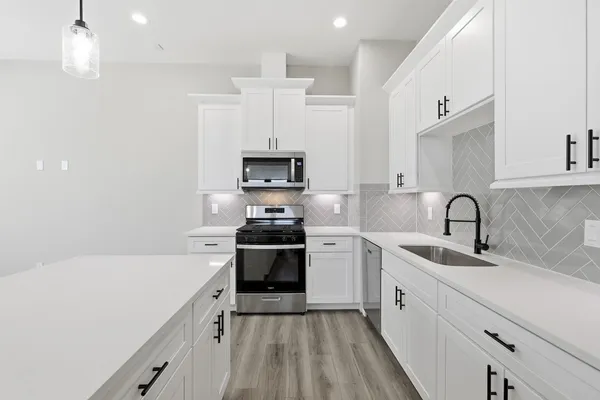 a kitchen with a sink a stove and cabinets