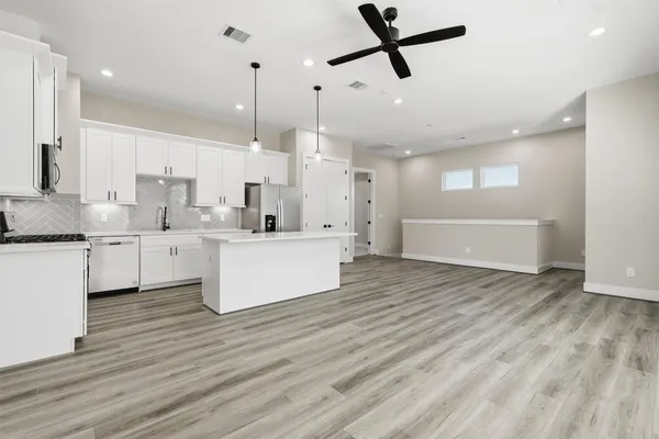a kitchen with white cabinets and stainless steel appliances