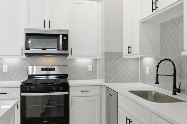 a view of a kitchen with a sink and wooden floor