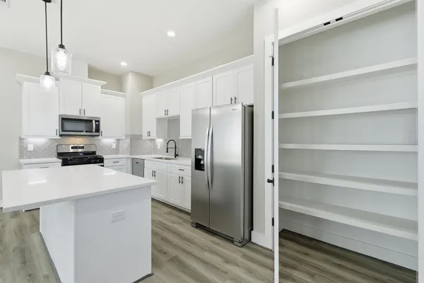 a kitchen with stainless steel appliances a stove a sink a microwave and cabinets