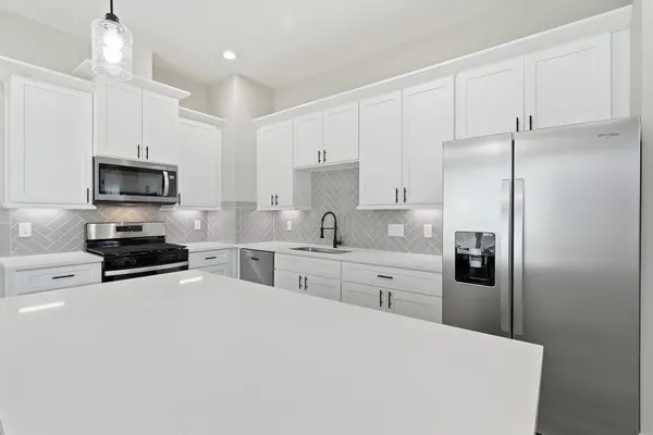 a large kitchen with cabinets and a wooden floor