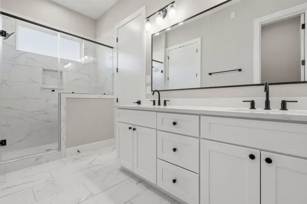 a bathroom with a shower sink and mirror