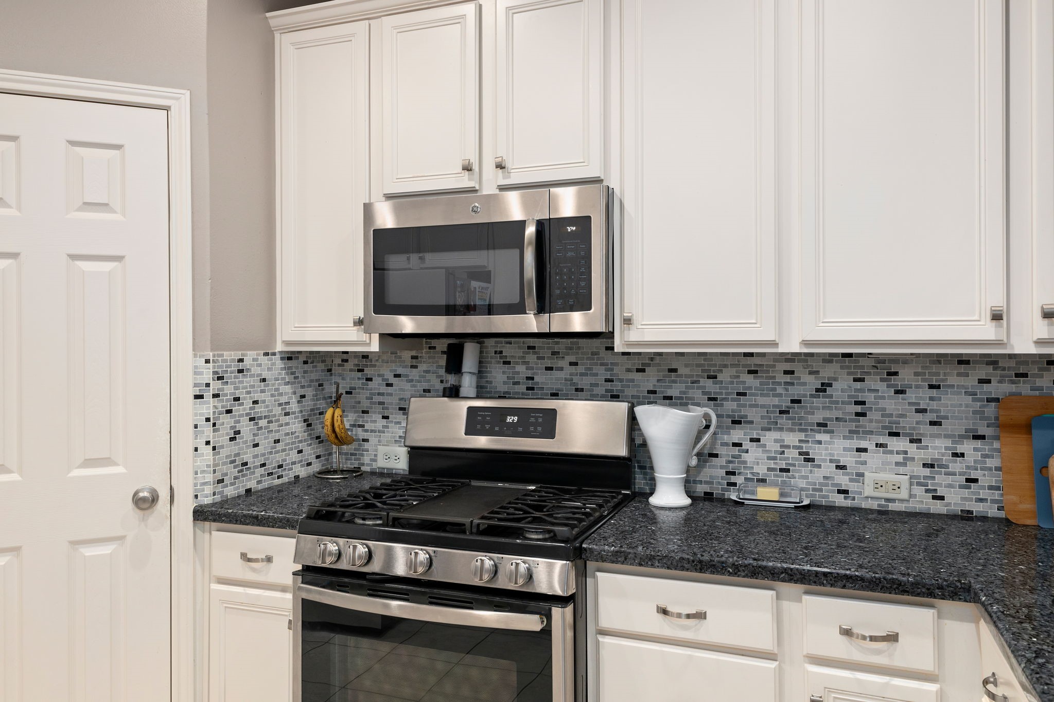 2709 Chase Street Brenham, TX 77833 - Photo 13 of 43 a kitchen with granite countertop white cabinets and stainless steel appliances