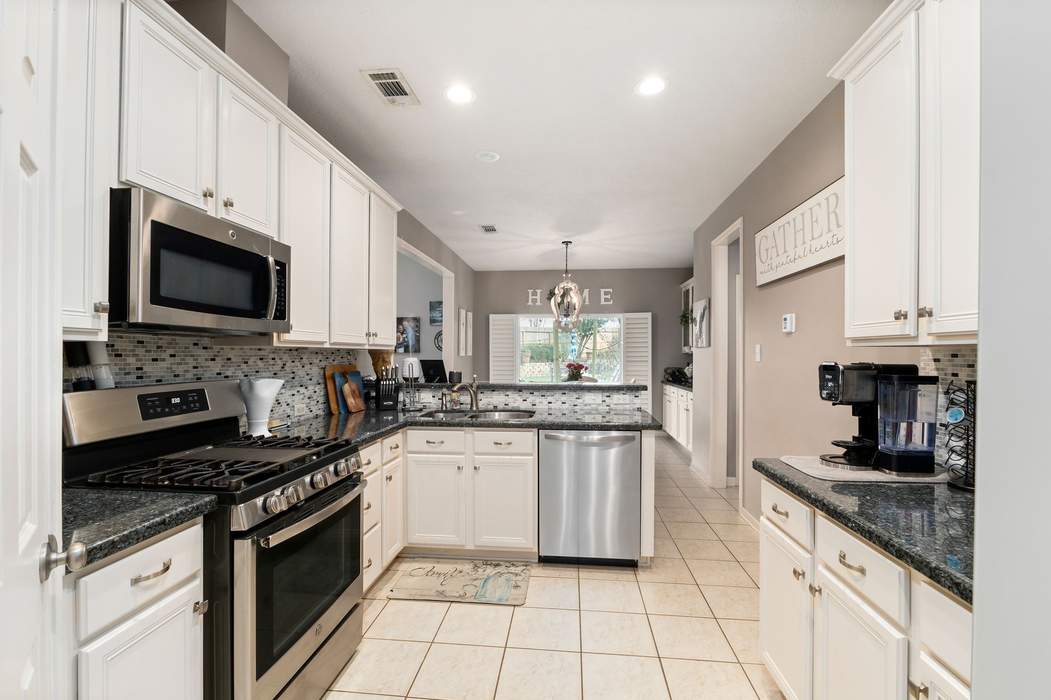 2709 Chase Street Brenham, TX 77833 - Photo 14 of 43 a kitchen with stainless steel appliances granite countertop a stove top oven a sink a counter space and cabinets