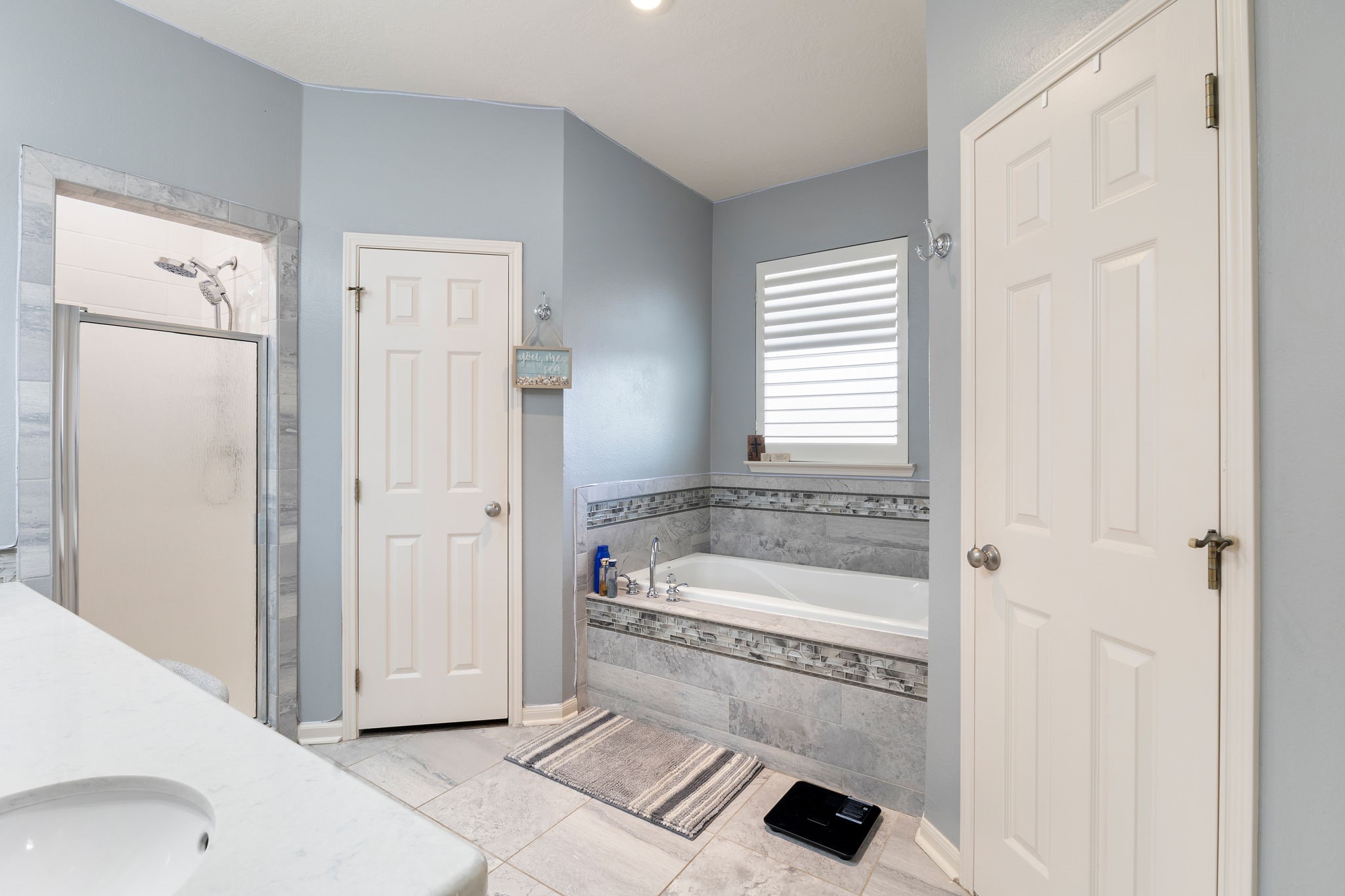 2709 Chase Street Brenham, TX 77833 - Photo 18 of 43 a bathroom with a tub a sink and a shower